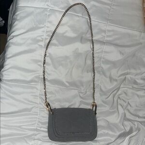 Gray cross body bag with gold-colored chain strap